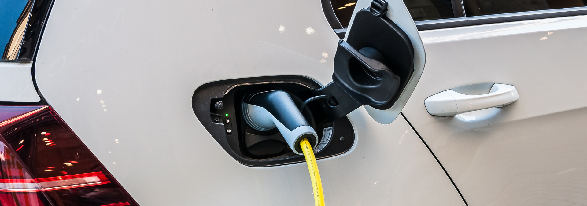 Ladestecker an einem weißen Elektroauto – Symbol für E-Mobilität bei Doberstein Elektrik